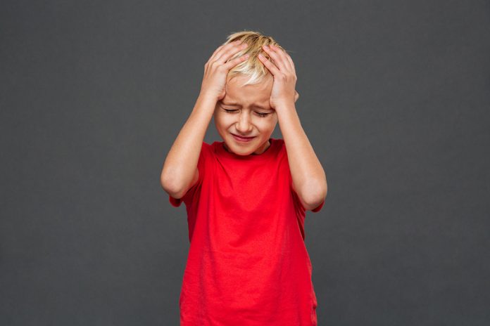 Sad little boy child with headache